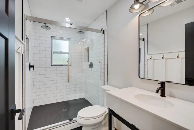 a bathroom with a sink toilet a mirror and shower