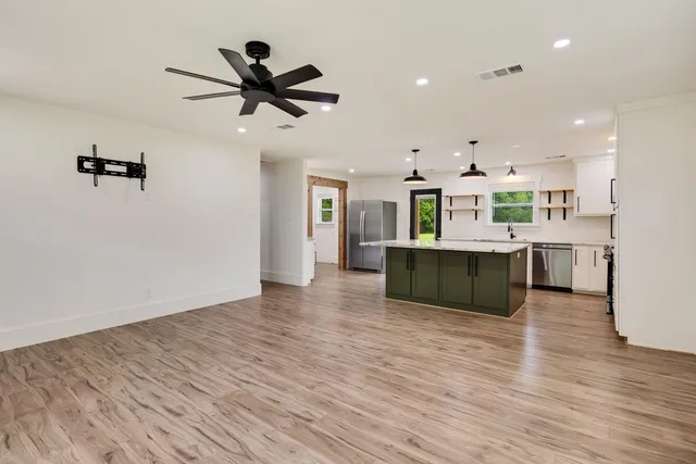 a living room with kitchen island furniture and a ceiling fan