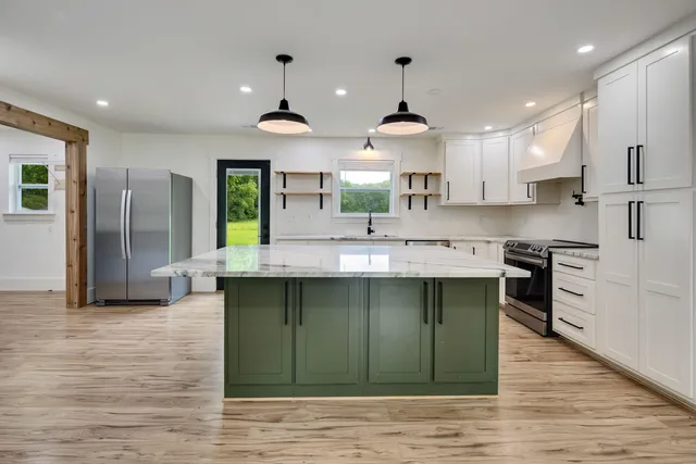 a kitchen with kitchen island a sink stainless steel appliances and cabinets