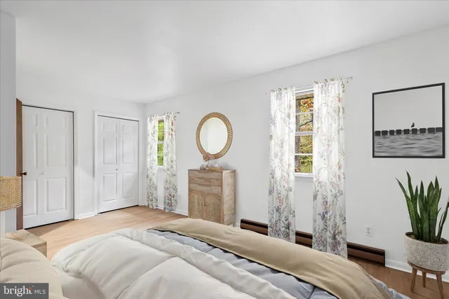 a bedroom with a bed and a potted plant next to a window