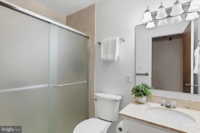 a bathroom with a granite countertop sink toilet and shower