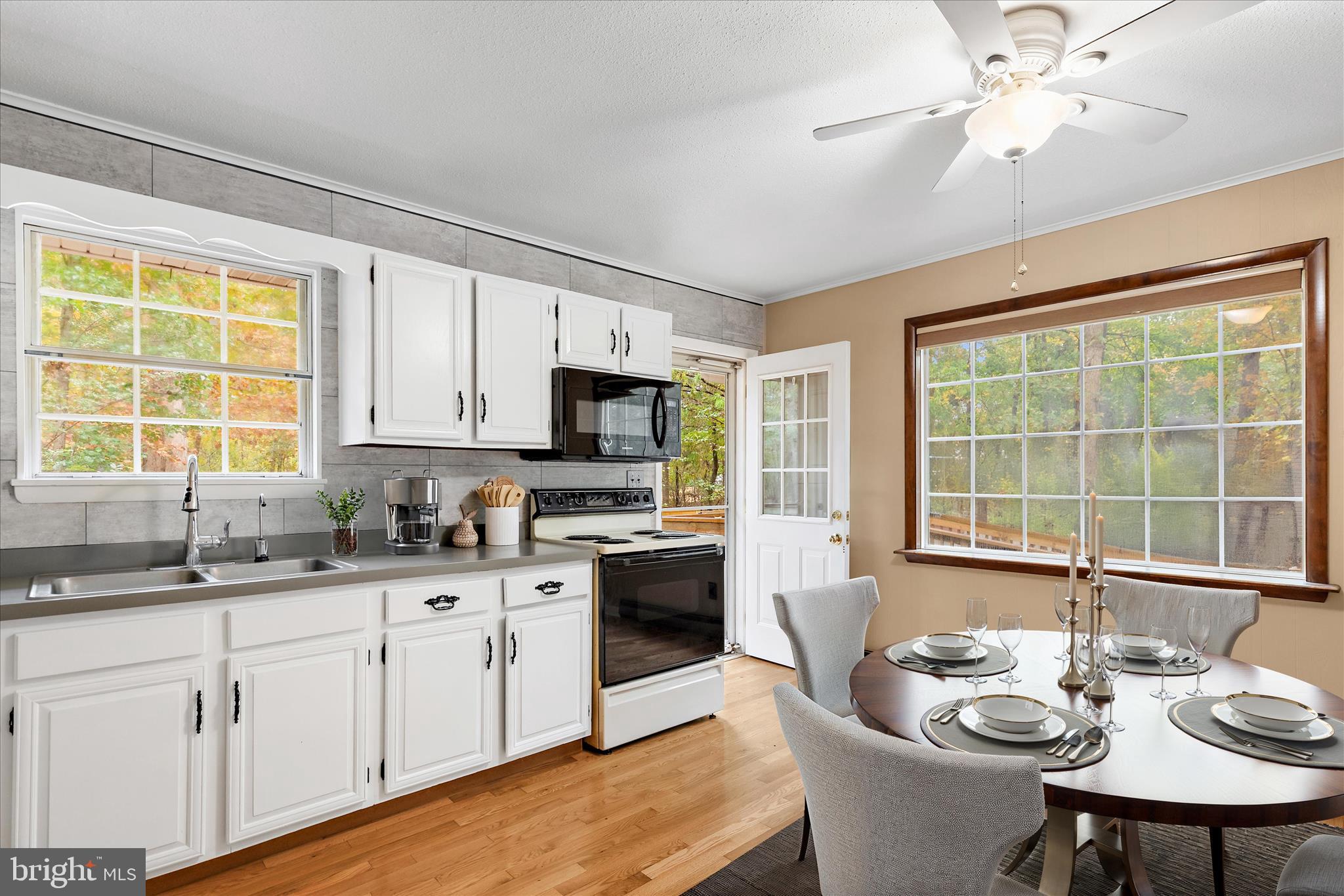 31703 Hickory Manor Road Frankford, DE 19945 - Photo 7 of 49 a kitchen with stainless steel appliances granite countertop a stove a sink dishwasher a dining table and chairs with wooden floor
