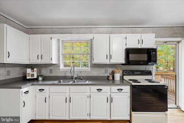 a kitchen with stainless steel appliances granite countertop a sink a stove and a microwave