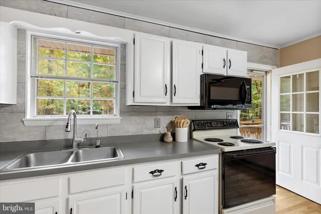 a kitchen with stainless steel appliances a sink a stove and microwave
