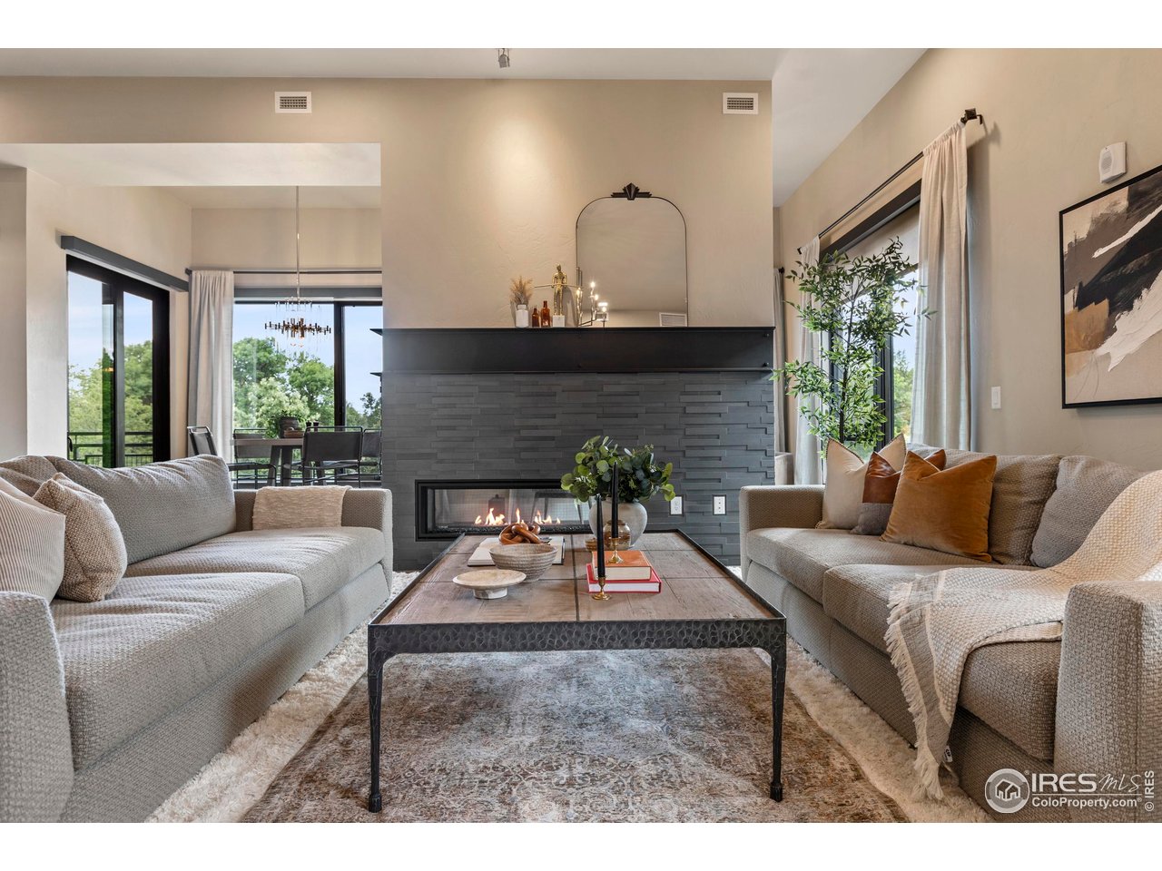 a living room with furniture a large window and a fireplace