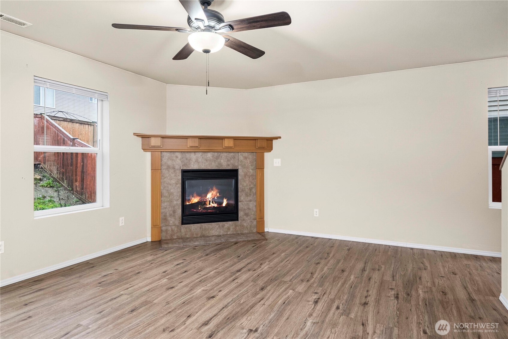 14942 99th Way Southeast Yelm, WA 98597 - Photo 11 of 37 a view of an empty room with wooden floor fireplace and a window