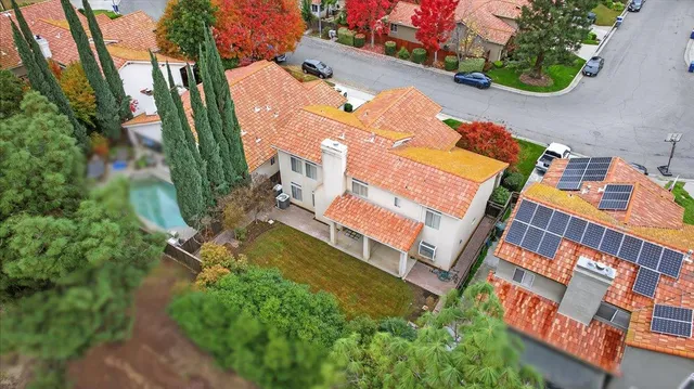 a view of a big room with a chandelier fan and wooden floor