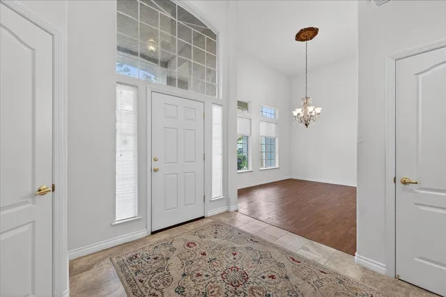a view of a room with wooden floor and chandelier