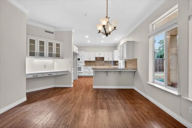 a kitchen with granite countertop a sink cabinets and wooden floor