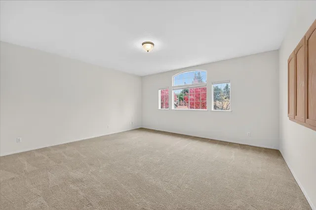 a spacious bathroom with a double vanity sink a large mirror a toilet and a shower