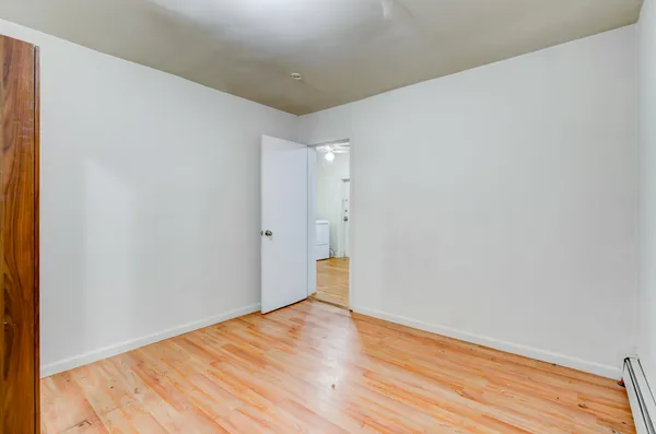 a view of empty room with wooden floor