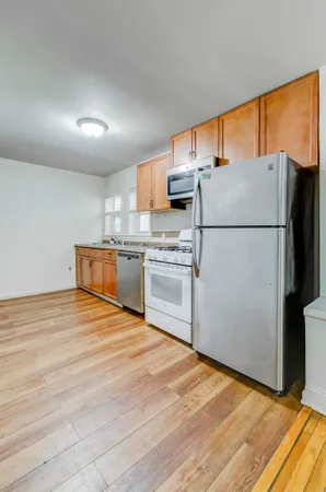 a kitchen with stainless steel appliances granite countertop a refrigerator sink stove and cabinets
