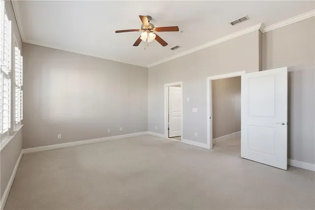 an empty room with windows and fan