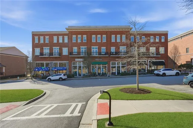 a view of a big building with a big yard and large trees