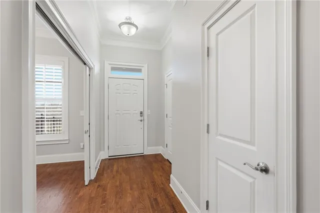 a view of an empty room with wooden floor and a chandelier