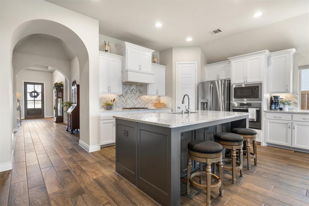 1647 Twistleaf Road Northlake, TX 76226 - Photo 9 of 39 a kitchen with stainless steel appliances a dining table chairs refrigerator and sink
