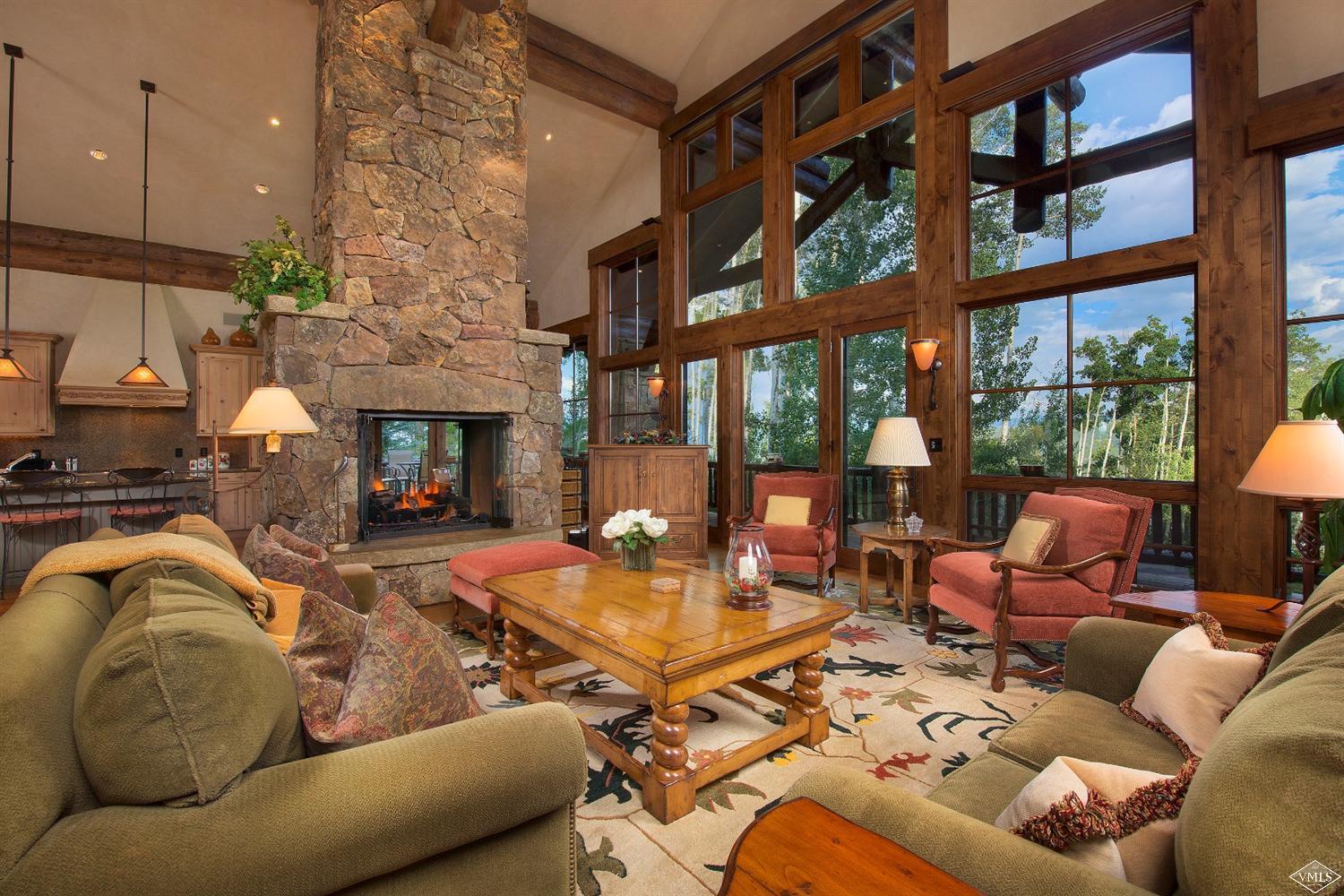 3508 Daybreak Ridge Road Avon, CO 81620 - Photo 1 of 25 a living room with furniture a fireplace and a floor to ceiling window