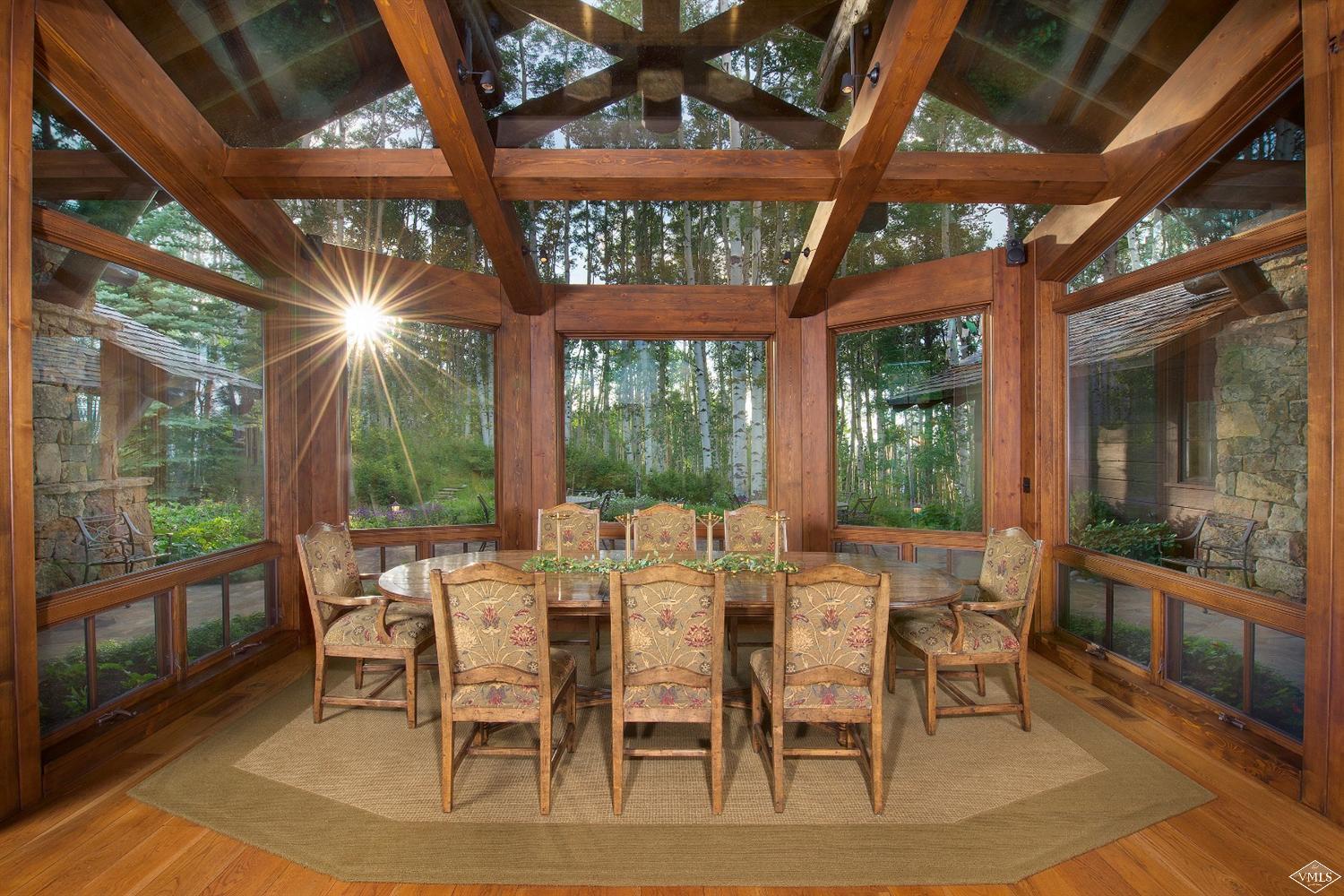 3508 Daybreak Ridge Road Avon, CO 81620 - Photo 4 of 25 a view of a patio with table and chairs and floor to ceiling window with wooden floor