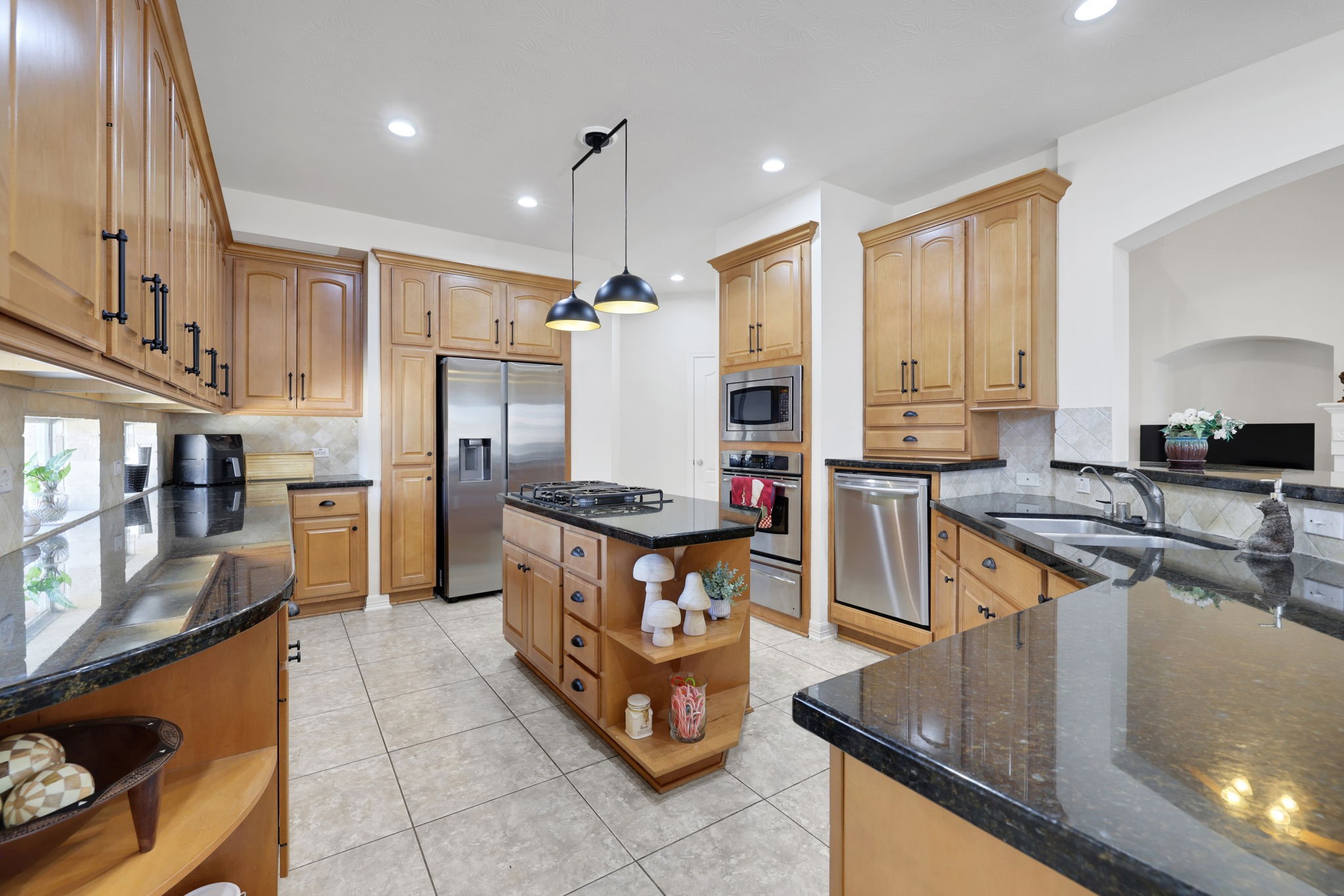20810 East Cameron Ridge Drive Cypress, TX 77433 - Photo 11 of 48 a kitchen with stainless steel appliances granite countertop a stove top oven a sink dishwasher a dining table and chairs with wooden floor