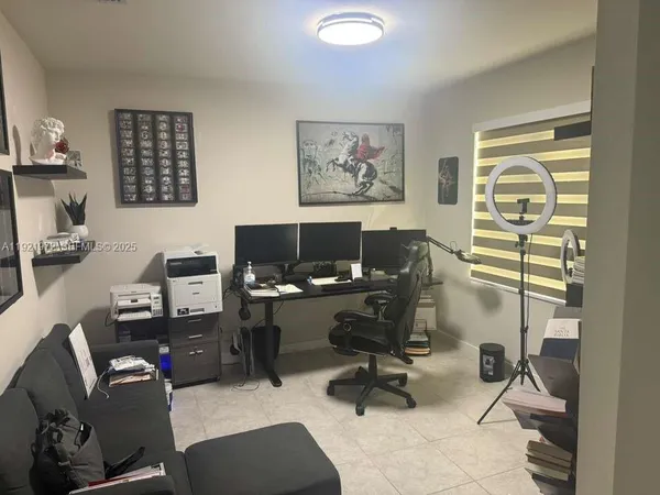 a view of a workspace with furniture and a window