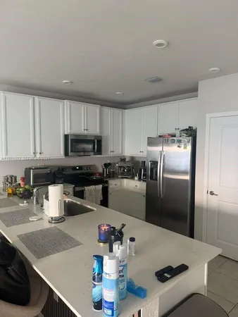 a kitchen with stainless steel appliances granite countertop a sink refrigerator and microwave