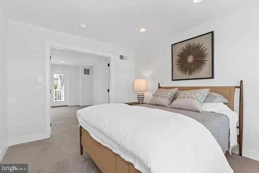 a spacious bedroom with a bed and painting on the wall