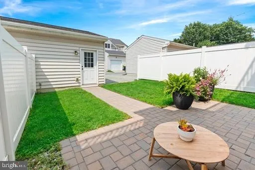 a backyard of a house with table and chairs plants