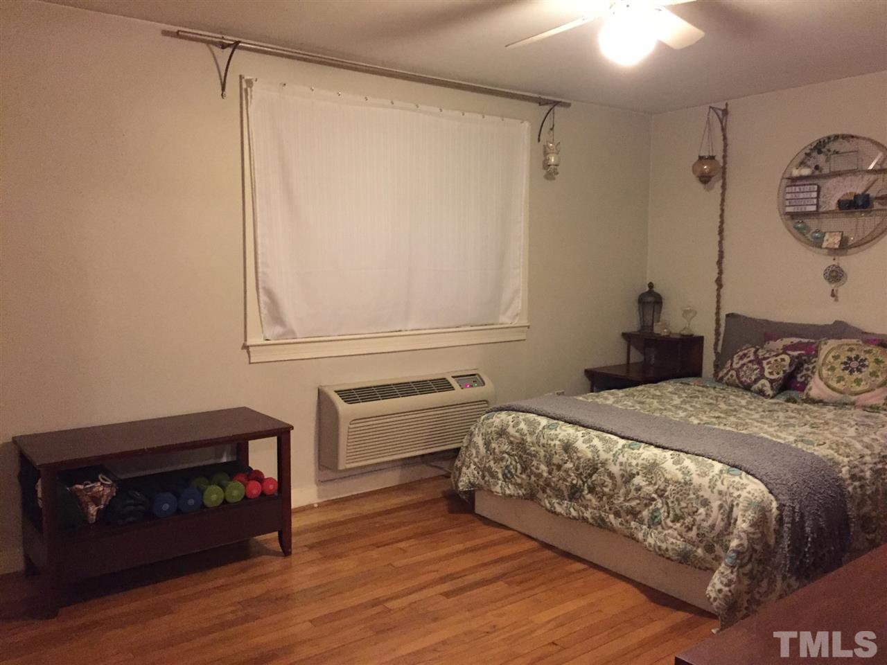 834 Bryan Street, Unit 834 Raleigh, NC 27605 - Photo 12 of 16 a bedroom with a bed and a fireplace