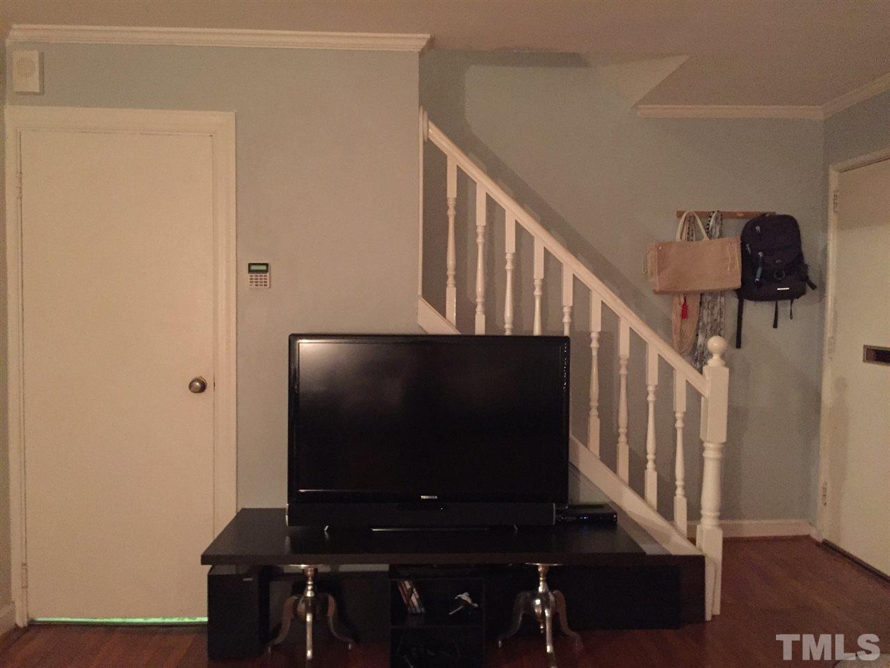834 Bryan Street, Unit 834 Raleigh, NC 27605 - Photo 7 of 16 a living room with wooden floor and a flat screen tv