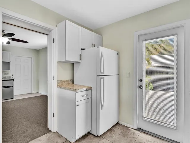 a kitchen with cabinets and a refrigerator