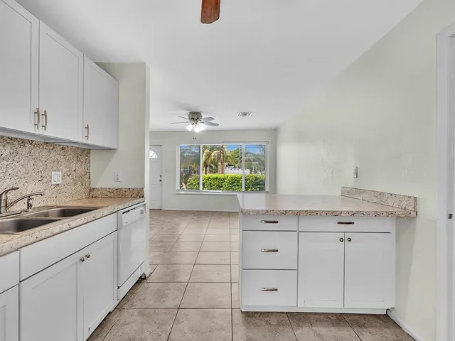 a kitchen with granite countertop white cabinets and white appliances