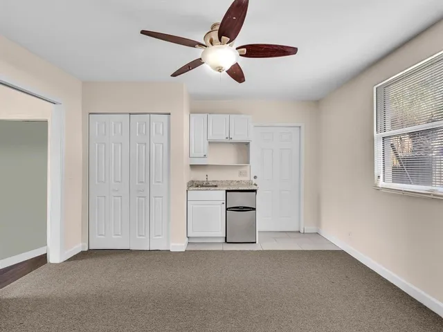 an empty room with windows and cabinet