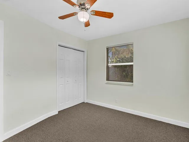an empty room with a window and a fan