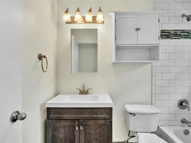 a bathroom with a sink toilet and mirror