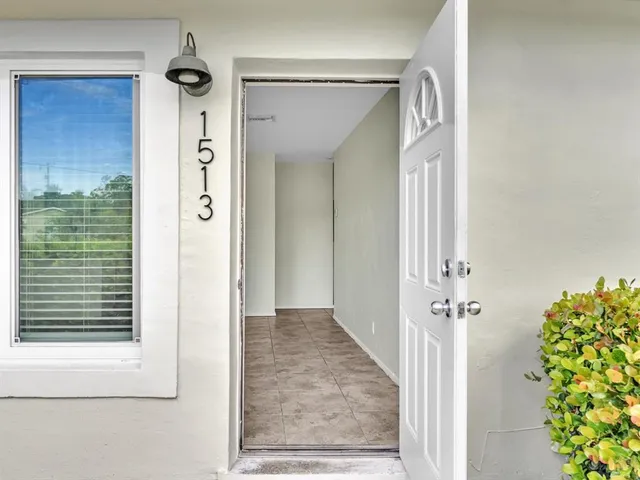 an entryway with a flower pot and a bookshelf