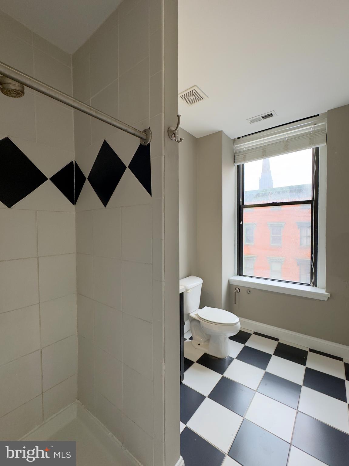 803 Cathedral Street, Unit 8 Baltimore, MD 21201 - Photo 13 of 16 a bathroom with a black and white checkered floor