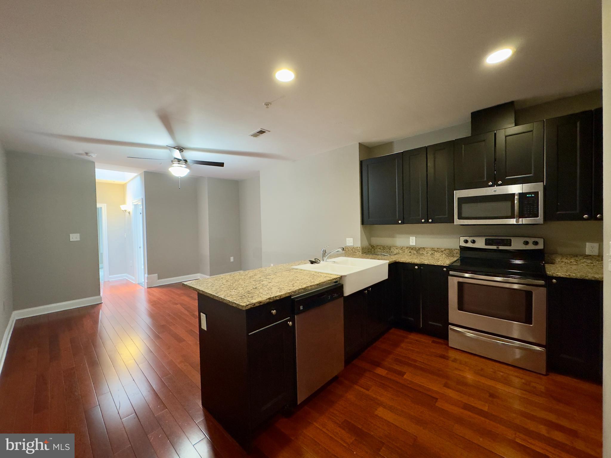 803 Cathedral Street, Unit 8 Baltimore, MD 21201 - Photo 2 of 16 a kitchen with stainless steel appliances granite countertop a sink stove and refrigerator