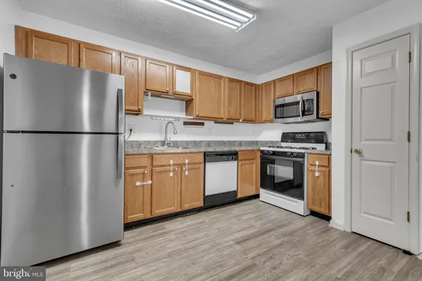 a kitchen with a refrigerator sink and wooden floor