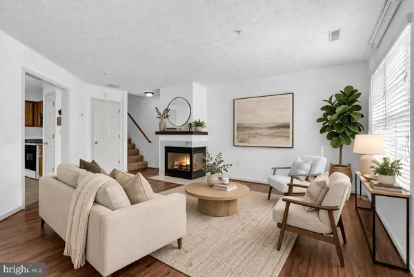 a living room with furniture a fireplace and a potted plant