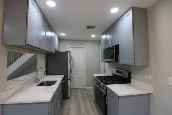 a kitchen with stainless steel appliances granite countertop a sink stove and refrigerator