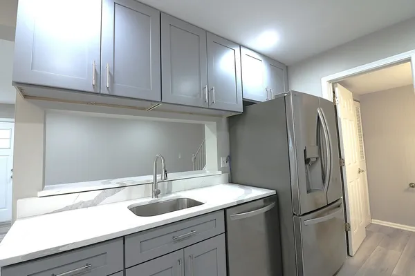a kitchen with stainless steel appliances granite countertop a refrigerator and a sink