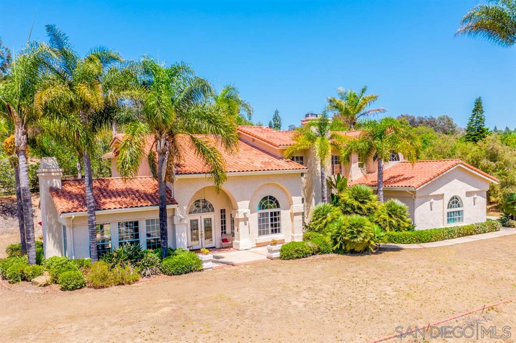 3022 Camino Del Rancho Encinitas, CA 92024 - Photo 1 of 18 a view of a white house with a small yard and palm trees