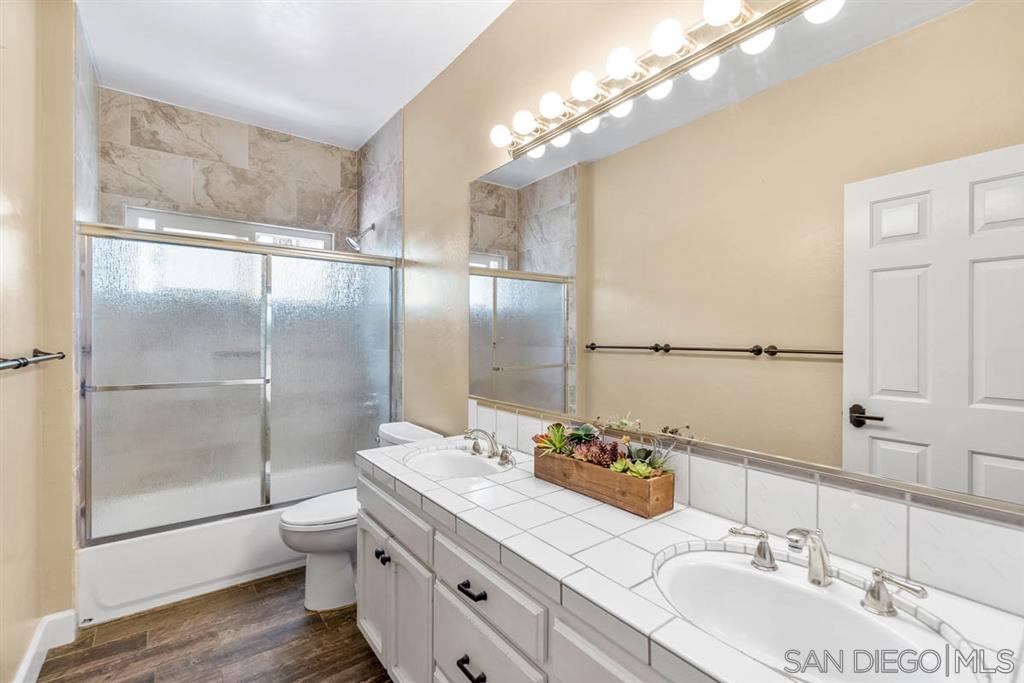 3022 Camino Del Rancho Encinitas, CA 92024 - Photo 14 of 18 a bathroom with a granite countertop sink a toilet and shower