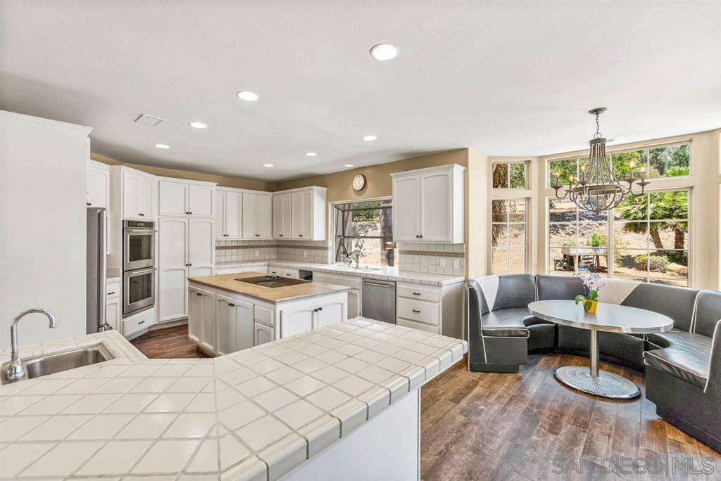 3022 Camino Del Rancho Encinitas, CA 92024 - Photo 8 of 18 a large white kitchen with a large window a sink and stainless steel appliances