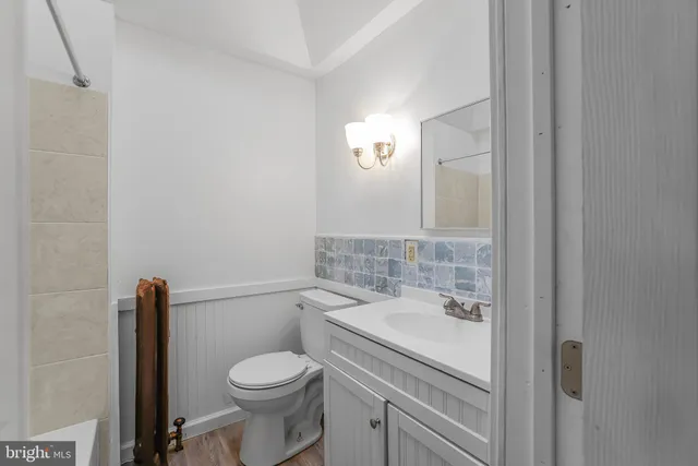 a bathroom with a granite countertop toilet sink and mirror