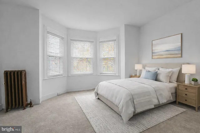a bedroom with a bed lamp and a window