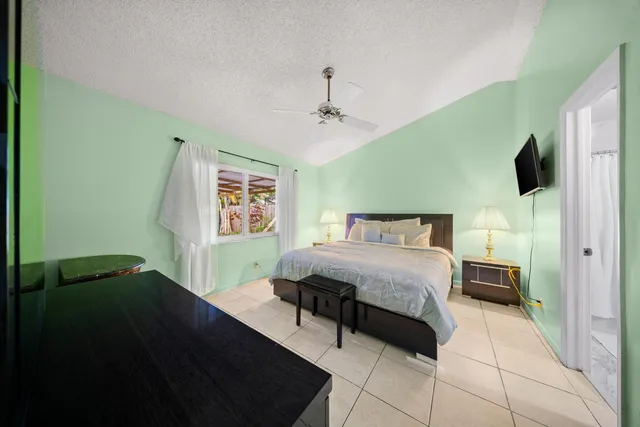 a backyard of a house with potted plants and large tree