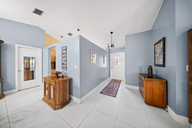 a open kitchen with stainless steel appliances kitchen island granite countertop a refrigerator a stove a dining table and chairs with wooden floor