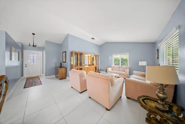 a living room with furniture a large window and gym equipment