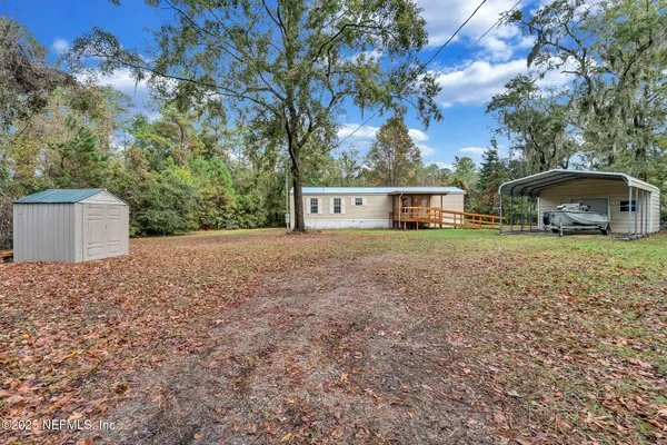 front view of a house with a yard and large trees